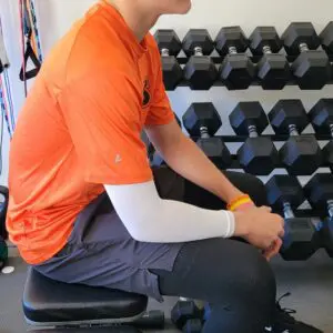 A man sitting on a bench in the gym