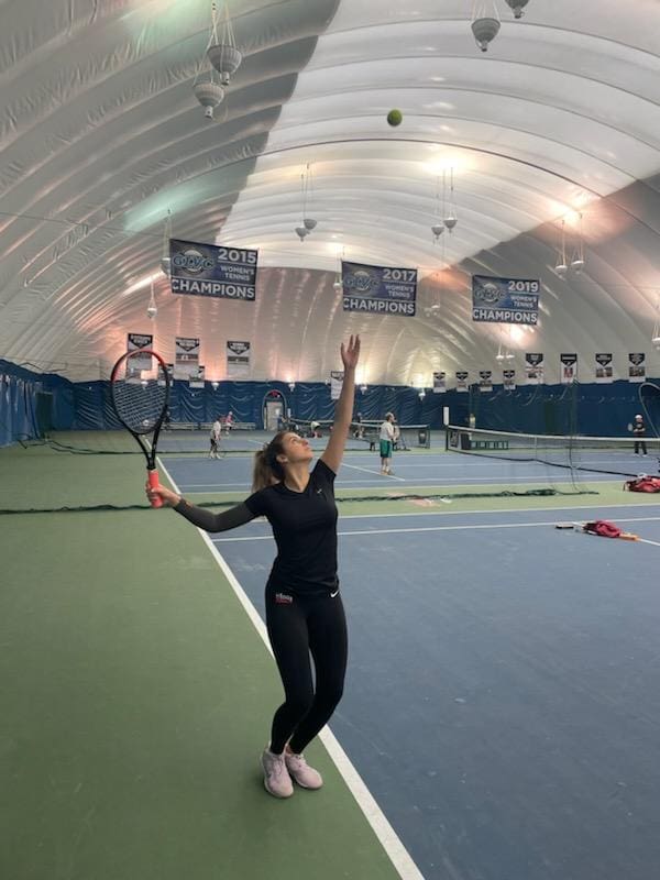 A woman holding a tennis racket in her hand.