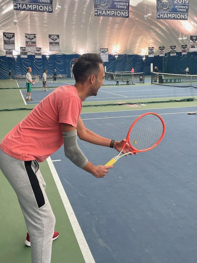 A man holding a tennis racket on the court