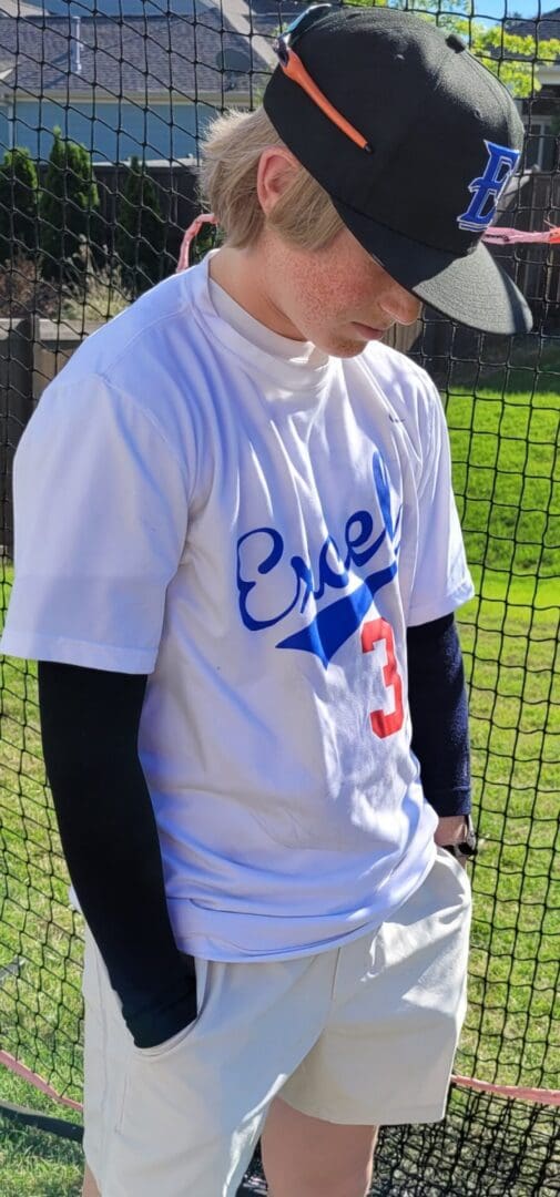 A baseball player wearing a white shirt and black sleeves.